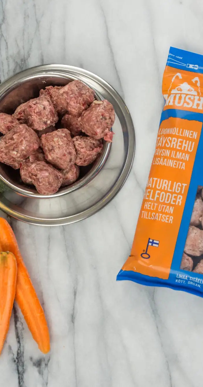 Blå og orange emballeret Vaisto-mærke voksen hundemad med et klart vindue, der viser køttbollerne indeni.