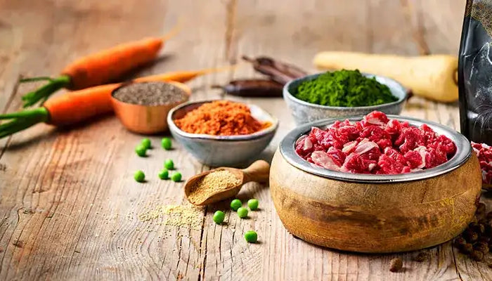 En rustik træskål fyldt med friske røde oksekødskiver.